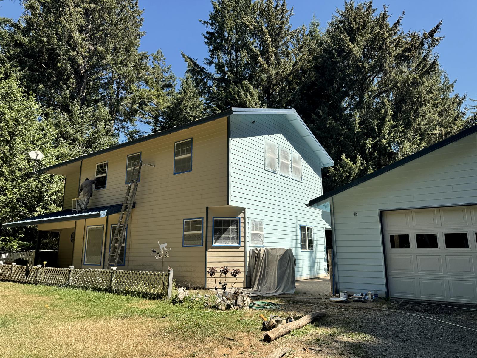 Two buildings on one property, the yellow house still being cut in while the pale blue wing and the garage stand finished.